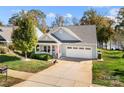 Charming blue house with a well-manicured lawn, a white picket fence and an attached two-car garage at 25566 Seagull Dr, Lancaster, SC 29720
