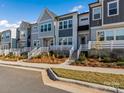 Row of townhouses showcasing a consistent design, landscaping, and white railings at 118 Berkeley Ave # D, Mooresville, NC 28117