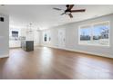 Bright living room featuring hardwood floors, a ceiling fan, and an open floor plan to the kitchen at 119 E Ohio Ave, Bessemer City, NC 28016
