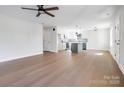 Spacious living room with hardwood floors, ceiling fan, and seamless flow into the modern kitchen at 119 E Ohio Ave, Bessemer City, NC 28016