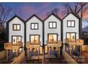 Rear view of three townhomes, each with a deck and fenced yard at 162 Mattoon St, Charlotte, NC 28216