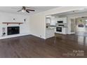 Open-concept living room featuring a fireplace, hardwood floors, and seamless access to the kitchen and adjacent spaces at 105 Victoria Dr, Statesville, NC 28625