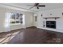 Bright living room featuring a brick fireplace, hardwood floors, and a large window providing ample natural light at 105 Victoria Dr, Statesville, NC 28625