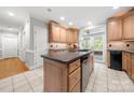 A large kitchen with an island sink, wood cabinets, recessed lights, and stainless steel dishwasher at 2545 Rea Rd, Charlotte, NC 28226