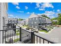 Neighborhood view from balcony showcasing well-maintained gray townhomes, green lawns, and neatly paved streets under a blue sky at 4018 Capital Ridge Ct, Charlotte, NC 28205