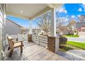 Covered porch with brick columns and a wooden bench at 131 Chimney Rock Ct, Denver, NC 28037