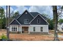 Beautiful exterior of home features stone accents, beige siding, black shutters and a front porch at 227 Heartland Dr, Rock Hill, SC 29732