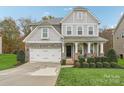 Two-story house with gray siding, stone accents, and a landscaped lawn at 2624 Woodlands Creek Dr, Monroe, NC 28110