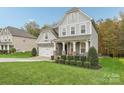 Two-story house with gray siding, stone accents, and a landscaped lawn at 2624 Woodlands Creek Dr, Monroe, NC 28110