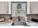 Close-up of a kitchen sink area featuring granite countertops and pendant lighting at 3018 Corinth Church Rd, Monroe, NC 28112