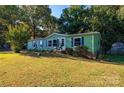 Green mobile home with landscaped yard and carport at 3401 Stony Brook Cir, Newton, NC 28658