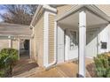 Front entrance of a tan colored townhouse with a small porch at 7062 Quail Hill Rd, Charlotte, NC 28210