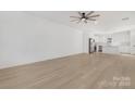 Open living room with kitchen island and light hardwood floors at 7415 Linda Lake Dr, Charlotte, NC 28215