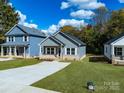 A well-manicured lawn frames a gray home featuring a concrete driveway and sidewalk at 606 Meadow Ave, Spencer, NC 28159