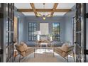 Study with dark-blue walls, wood beams, and built-in shelving at 705 Mcalway Rd, Charlotte, NC 28211