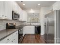 Modern kitchen with white cabinets, stainless steel appliances, and dark countertops at 105 Beverly Chase Ln, Mooresville, NC 28117