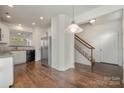 Kitchen with hardwood floors, stainless steel appliances, and access to stairs and entryway at 105 Beverly Chase Ln, Mooresville, NC 28117