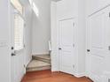 Bright entryway with staircase, coat closet and hardwood floors at 2030 Cambridge Beltway Dr, Charlotte, NC 28273