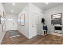 Welcoming entryway featuring coat rack, bench, artwork and adjacent laundry room with modern appliances at 2561 Blue Sky Meadows Dr, Monroe, NC 28110