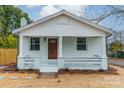 Newly renovated white house with brown door, porch, and landscaping at 119 Nat Barber Ave, Gastonia, NC 28052