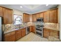 Well-appointed kitchen with stainless steel appliances, granite counters, tile backsplash, and ample cabinet space at 4919 Polo Gate Blvd, Charlotte, NC 28216
