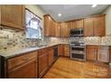 Kitchen features granite countertops, tile backsplash, and wood cabinets at 4919 Polo Gate Blvd, Charlotte, NC 28216