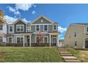 Two-story townhome with green siding, brick accents, and a landscaped lawn at 9744 Inkberry Dr, Gastonia, NC 28056