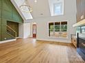 Open-concept area featuring wood floors, high ceilings, fireplace, and large windows with backyard views at 4539 Polk Ford Rd, Stanfield, NC 28163