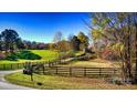 Long driveway entrance to home with wooden fence and autumn trees at 448 Johnson Dairy Rd, Mooresville, NC 28115