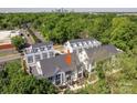 An aerial shot shows the townhome complex with modern architecture, surrounded by lush greenery and city skyline at 1419 Collier Walk Aly # Csw0208, Charlotte, NC 28205