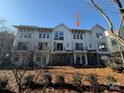 Shot of townhome featuring brick accents, siding, and upper balconies, nestled among the trees at 1419 Collier Walk Aly # Csw0208, Charlotte, NC 28205