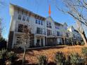 Modern townhome, white exterior, multiple balconies, tree-lined street at 1421 Collier Walk Aly # Csw0209, Charlotte, NC 28205