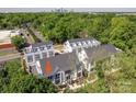 Aerial view of modern townhomes surrounded by lush greenery with a cityscape view in the background at 1423 Collier Walk Aly # Csw0210, Charlotte, NC 28205