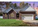 Brick house with white garage door and landscaping at 1009 Amber Ct, China Grove, NC 28023