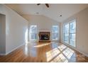 Bright living room with a vaulted ceiling, hardwood floors, brick fireplace, and large windows for natural light at 117 Eagle Ct, Mooresville, NC 28117