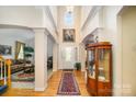 Two-story entryway with hardwood floors and decorative cabinet at 2111 Priory Ct, Charlotte, NC 28262