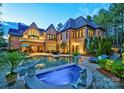 Luxury home with pool and spa, surrounded by lush landscaping at 16908 Ashton Oaks Dr, Charlotte, NC 28278