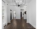 Bright dining room with dark hardwood floors and a modern chandelier at 216 Devon Forest Dr, Mooresville, NC 28115