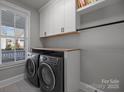 Laundry room with white cabinets, wood countertop, and washer/dryer at 440 Luray Way, Rock Hill, SC 29730