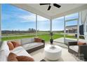 A bright screened porch featuring a ceiling fan, outdoor seating, and expansive green views at 885 Exeter Dr, Sherrills Ford, NC 28673