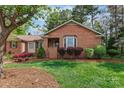 Charming brick home with well-maintained lawn, colorful flower beds, and mature trees at 206 Swaim Ct, Salisbury, NC 28147