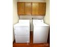 Functional laundry area with washer, dryer, and overhead storage cabinets at 206 Swaim Ct, Salisbury, NC 28147