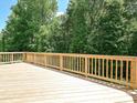 Spacious wooden deck with railing overlooks a private, tree-lined backyard at 2387 Trundle Dr # Cwo0155, Gastonia, NC 28054