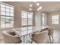 Modern dining room with marble table, light fixture and hardwood floors, plus a view to entryway at 13905 Castle Nook Dr, Charlotte, NC 28273