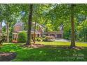 Charming home surrounded by mature trees and verdant greenery with a well-manicured lawn at 20361 Enclave Oaks Ct, Cornelius, NC 28031