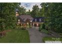 Lovely house with lush landscaping, stone accents, and a spacious driveway in a wooded setting at 20361 Enclave Oaks Ct, Cornelius, NC 28031