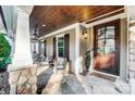 Inviting front porch with stone accents, ceiling fan, and a cozy seating area perfect for enjoying the outdoors at 20361 Enclave Oaks Ct, Cornelius, NC 28031