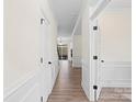 Hallway with hardwood floors, white walls, crown molding and entry to other rooms at 122 W Heart Pine Ln, Statesville, NC 28677