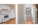 Well-equipped kitchen with white cabinets and wood flooring at 3312 Heathstead Pl, Charlotte, NC 28210