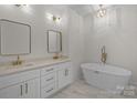 Elegant bathroom with dual vanities, soaking tub, and gold fixtures at 2410 Brantley Rd, Kannapolis, NC 28083